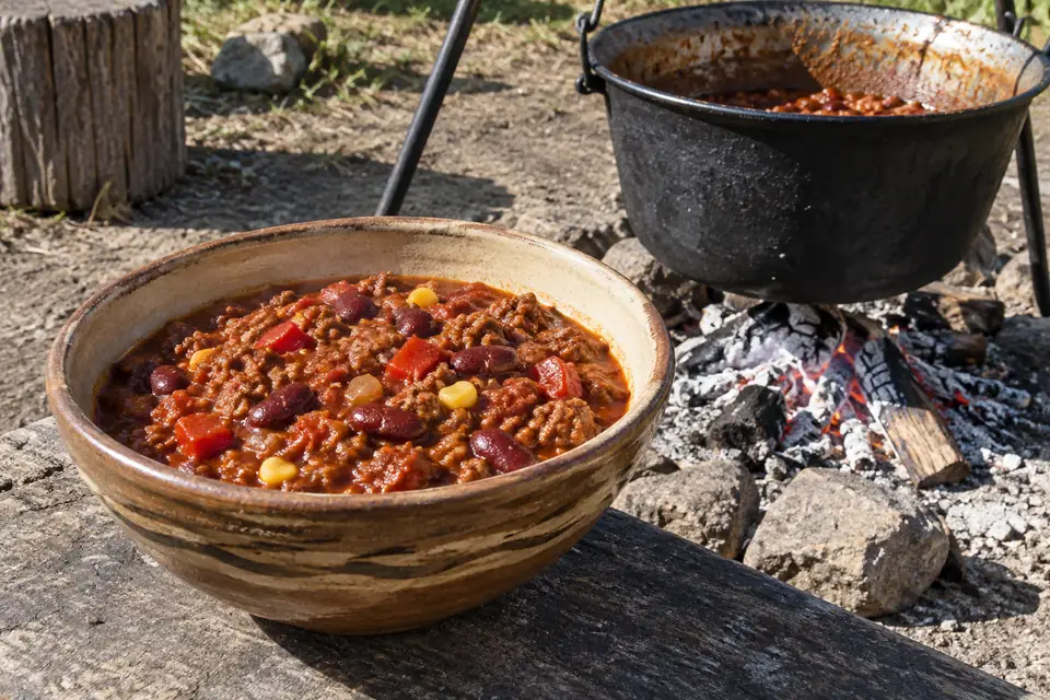 Bográcsos chilis bab rusztikus tálban, sűrű marhahúsos paradicsomszafttal, vörösbabbal és kukoricával